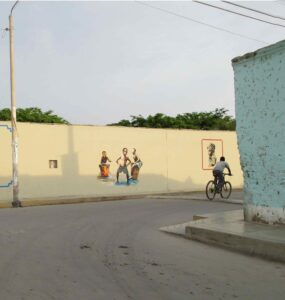 street in coastal Peru with mural showing a bicyclist and black latino boys playing the cajon